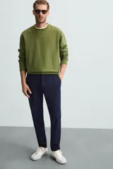 Pantalón largo de vestir gris claro con estampado de cuadros, corte slim fit y cintura elástica. Confeccionado en tejido con alta elasticidad, bolsillos frontales y cierre frontal con cremallera y botón.