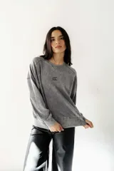 Buzo gris con efecto lavado, cuello redondo y calce oversize.