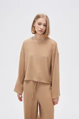 Top color beige de manga larga, holgado y cuello redondo.