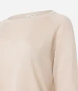 Suéter de punto color crema, de corte amplio, con cuello redondo y mangas largas.