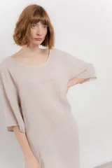 Vestido midi de lino con corte relajado y silueta fluida. Presenta escote redondo, mangas 3/4 y bolsillos laterales. Diseño minimalista y atemporal ideal para el verano.