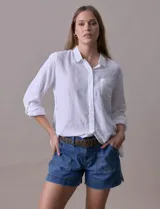 Camisa blanca de lino, marca Dash, con cuello con solapa, abertura central con botones, bolsillo aplicado en el pecho y mangas largas regulables con presilla y botón.