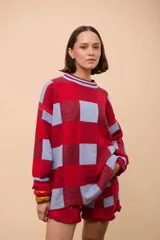 Sweater de punto con diseño a cuadros rojos y celestes, de corte holgado y cuello redondo.