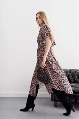 Vestido midi con estampado animal print, mangas cortas amplias, escote en V, cintura elastizada tipo nido de abeja, tajo central y ruedo asimétrico en picos.