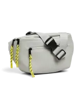 Riñonera color gris claro de poliéster con efecto cuero, correa ajustable con hebilla plástica negra, cierre superior con cremallera y tiradores de cuerda amarilla.