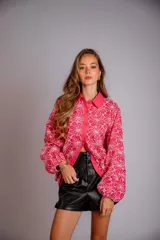 Camisa celeste con estampado de flores blancas, corte clásico, cuello camisero y mangas largas abullonadas.