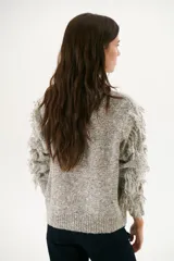 Sweater color arena de tejido de punto con cuello redondo y mangas largas con flecos.