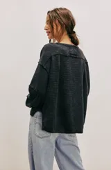 Camiseta de manga larga color verde oliva, con textura acanalada y silueta holgada extragrande. Presenta escote redondo, hombros caídos y puños anchos.