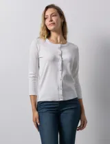 Cardigan blanco de tejido fino con abertura central y botones.