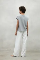 Camiseta gris de manga corta con cuello redondo y texto estampado en el pecho.