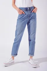 Jean de mujer tiro medio, color celeste claro, corte Mom. Confeccionado en algodón peinado.