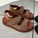 Sandalias de cuero color marrón con doble tira con hebilla ajustable, plantilla de cuero y suela de goma.