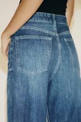 Pantalón de jean rígido celeste con tiro alto, cinco bolsillos, trabillas en la cintura, pierna ancha y largo hasta el tobillo.