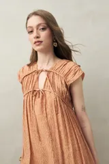 Vestido largo con estampado floral celeste y blanco, escote ajustable con lazo y frunce en la parte superior.