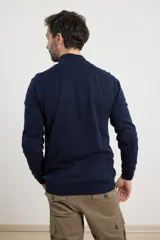 Cardigan azul de tejido de punto con cierre frontal y cuello alto.