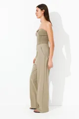 Pantalón de vestir color beige con pinzas, tiro alto, cintura elástica, bolsillos al bies y piernas amplias con raya adelante. Corte relajado.