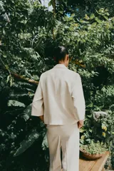 Pantalón de vestir color beige, de tiro alto, con cintura elástica en la parte trasera, bolsillos delanteros y falsos bolsillos de vivo en la parte trasera.