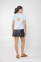 Remera celeste de manga corta con costuras verticales en el frente.