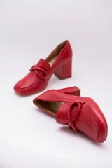 Zapato clásico de cuero azul marino, con aplique decorativo en el empeine y taco cuadrado.