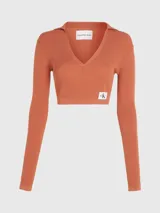 Sweater cropped color naranja de lyocell con textura de canalé, cuello polo en pico, mangas largas e insignia con el monograma de Calvin Klein en el bajo.