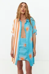 Minifalda celeste con estampado de soles naranjas y amarre lateral.