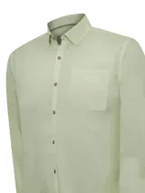 Camisa de manga larga color verde claro, confeccionada en popelina de algodón orgánico. Tiene cuello camisero, bolsillo de parche en el pecho izquierdo, botones de madera y protección solar UPF +20.