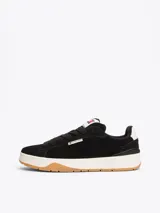 Zapatillas urbanas Tommy Jeans de corte bajo, color negro, confeccionadas en ante con interior de poliéster, entresuela texturizada color crema y suela de goma color caramelo. Presentan logo de la marca en el lateral y en la lengüeta.