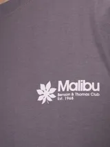 Remera azul con estampa en la espalda que incluye la palabra 'Malibu', una flor de hibisco y la frase 'Beach Bar, Summer Drinks & Fresh Sealt'.