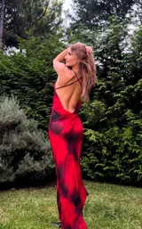 Vestido largo de microtul rojo con estampado abstracto negro, escote drapeado y breteles finos.