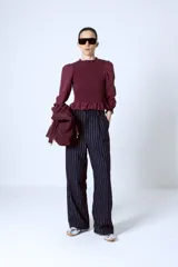 Blusa color borgoña con escote redondo con volados, mangas largas abullonadas y cuerpo fruncido.