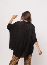 Camisa negra con calados, escote en V, abotonada y manga 3/4.