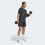 Remera de entrenamiento Adidas de manga corta y cuello redondo, color negro, con un patrón texturizado de espiga en relieve tono sobre tono. Presenta un corte ajustado (slim fit) y el logo de Adidas en el pecho.