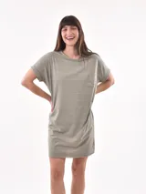 Vestido corto color verde militar con rayas horizontales blancas, corte recto, cuello redondo y bolsillo en el pecho. Mangas cortas con dobladillo.