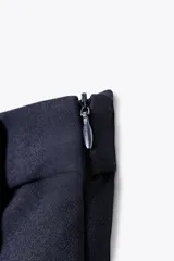 Falda pantalón corta color azul marino, de tiro alto y corte recto. Presenta doble hilera de botones blancos en el frente y cierre lateral con cremallera oculta.