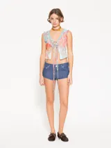 Mini short de tiro bajo, súper corto, color azul. El denim tiene una textura con relieve y desgastes.