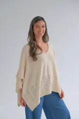 Poncho de tejido de punto color crudo, con escote en V y detalle calado en el ruedo.
