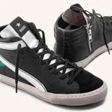 Zapatilla botita de cuero negro con aplique plateado y estrella verde, equipada con suela de caucho.