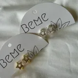 Par de aros pequeños con forma de estrella, disponibles en color dorado y plateado, con incrustaciones de strass.