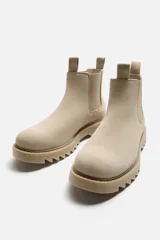 Bota Chelsea color beige de cuero, con elásticos laterales, tiradores delanteros y traseros, y suela track.
