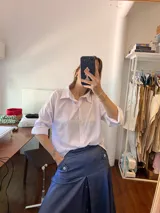 Camisa blanca de crepé con cuello clásico, manga larga y corte holgado.