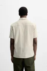 Camisa celeste de corte recto, manga corta y cuello solapa.