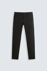Pantalón chino de corte skinny fit color negro, confeccionado en tejido de mezcla de algodón y elasticidad. Cuenta con bolsillos frontales y traseros de vivo. Cierre frontal con cremallera y botón.