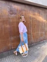 Bolso tipo tote de lona color crudo con detalles en cuero color marrón. Tiene doble asa corta de mano y correa larga de hombro.