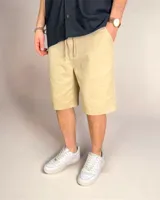 Bermuda color beige de lino, corte holgado con cordón ajustable en la cintura.