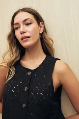 Musculosa negra con bordado calado y cierre frontal con botones.