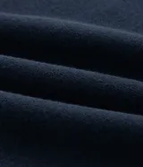 Buzo de manga larga color azul marino, confeccionado en tejido de algodón con felpa, con cuello polo blanco contrastante y abertura frontal con botones.