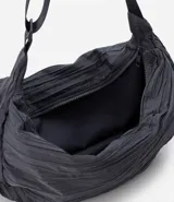 Bolso hobo mediano color gris oscuro con textura plisada y correa transversal ajustable.