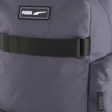 Mochila Puma Deck color gris oscuro con logo Puma estampado en blanco. Tiene dos correas frontales negras con hebillas, bolsillo lateral y superior con cierre.