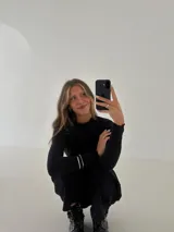 Remera gris de morley de algodón, de manga larga, con terminaciones fruncidas en cuello y mangas.