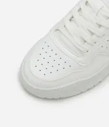 Championes urbanos blancos de cuero sintético con efecto floater, puntera redonda y perforaciones.